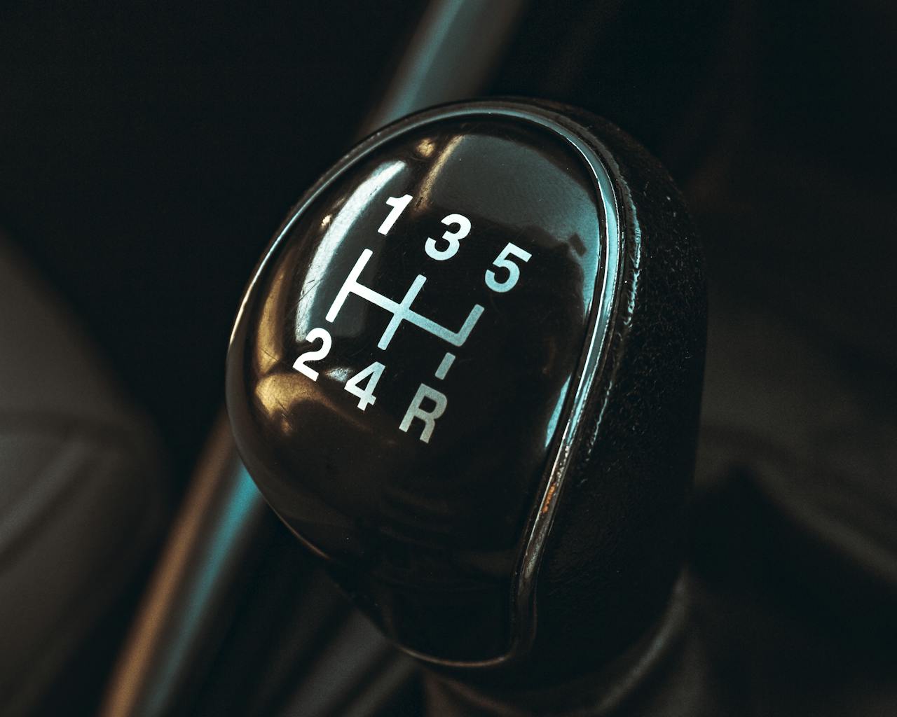 Detailed view of a car gearshift lever highlighting control and mechanics.